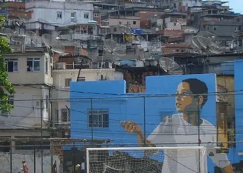 O futebol na Vila Cruzeiro sempre foi importante para a comunidade e preparou o terreno para o surgimento de Adriano, o Imperador. Foto: Facebook Vila Cruzeiro No alto, Igreja da Penha. Morro abrigava quilombo no século 19. Décadas depois, surgem favelas como a Vila Cruzeiro. Foto: Rio Antigo Estátua dos mestres Touro e Dentinho no Largo da Penha, instalada em 2021 em homenagem aos capoeiristas. Foto: Selma Souza/Voz das Comunidades Adriano Imperador desfila na Camisa Verde e Branco, em São Paulo, no Sambódromo do Anhembi, em 2024. Foto: Paulo Pinto/AB - Todos os direitos: @ Terra